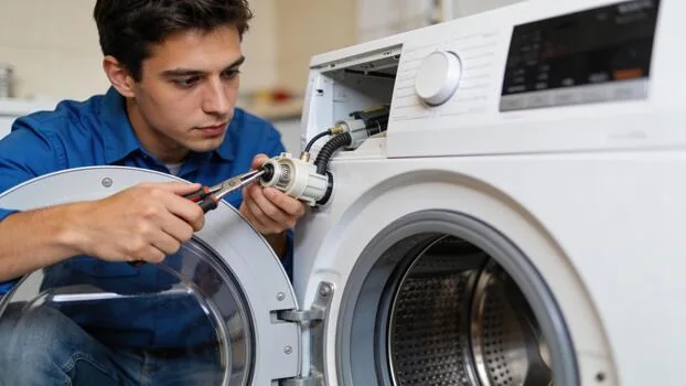 Appliance technician repairing a front-loading washing machine component