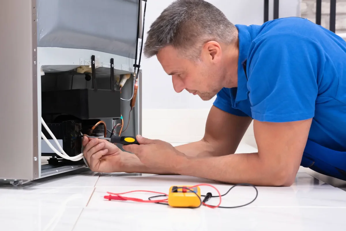Technician checking refrigeration components with a multimeter