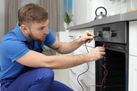 Technician testing the control panel of a built-in oven